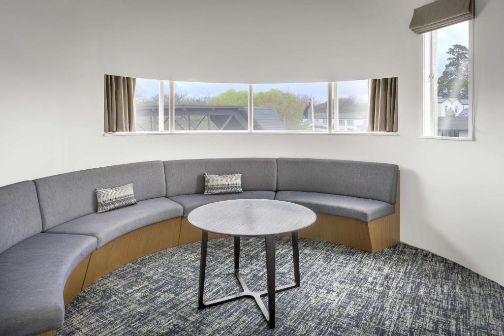 a living room with a couch and a table at Chateau On The Park - Christchurch, A Doubletree By Hilton in Christchurch