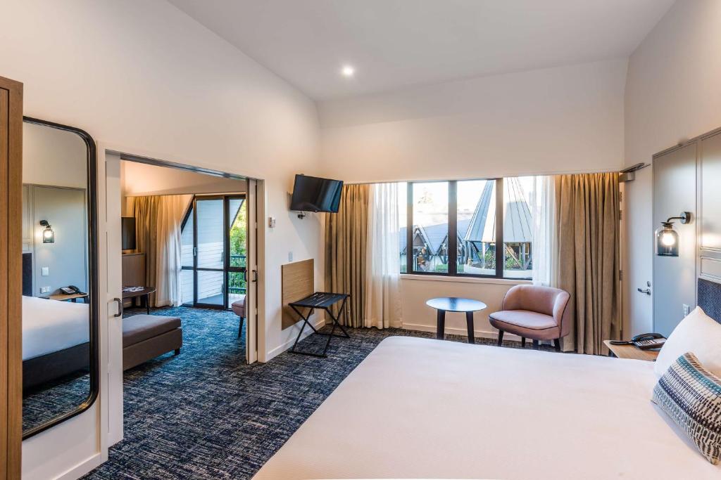 a hotel room with a bed and a desk at Chateau On The Park - Christchurch, A Doubletree By Hilton in Christchurch