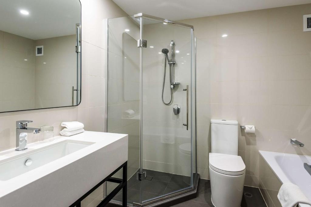 a bathroom with a shower and a sink and a toilet at Chateau On The Park - Christchurch, A Doubletree By Hilton in Christchurch