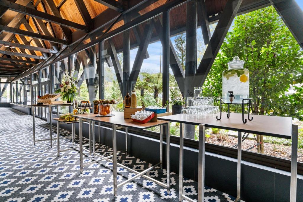 a row of tables in a room with windows at Chateau On The Park - Christchurch, A Doubletree By Hilton in Christchurch