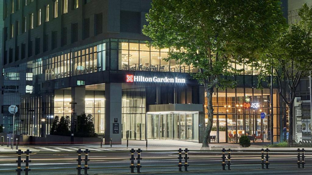 een groot glazen gebouw met een bord erop bij Hilton Garden Inn Seoul Gangnam in Seoul