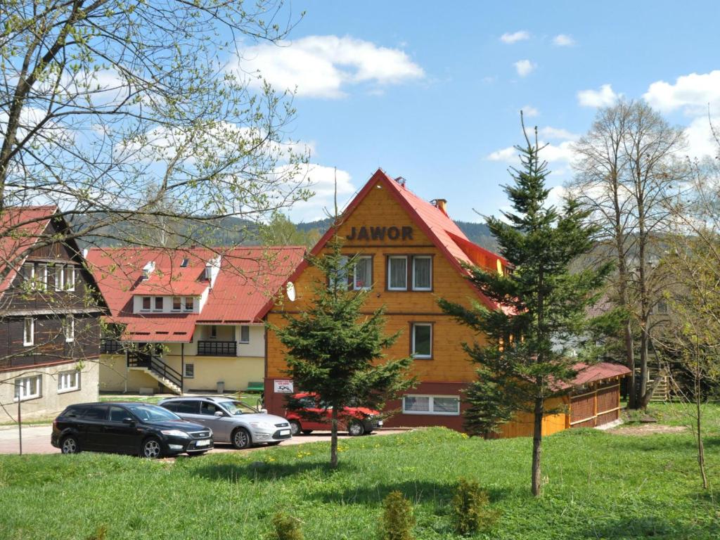 a building with cars parked in front of it at Dom Goscinny Jawor Czarnypotok in Krynica Zdrój