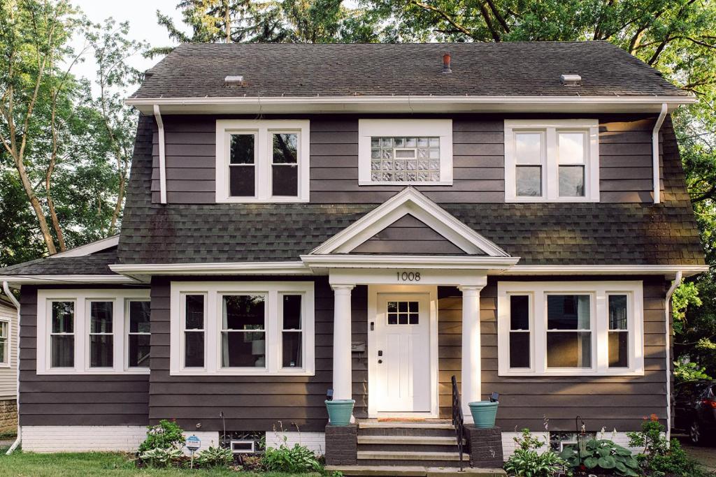 una casa negra con una puerta y ventanas blancas en The 1920’s Dutch Colonial - Highland Square, en Akron