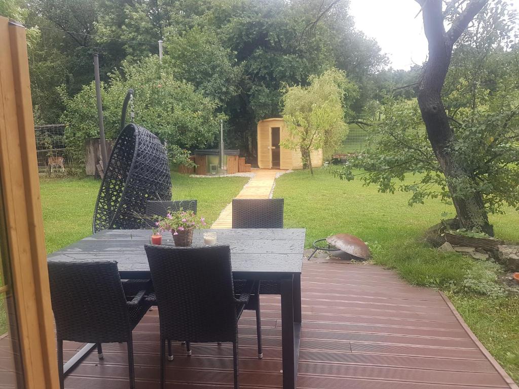 a table and chairs on a patio with a garden at Wellness Vejminek na farmě u koní in Milešov