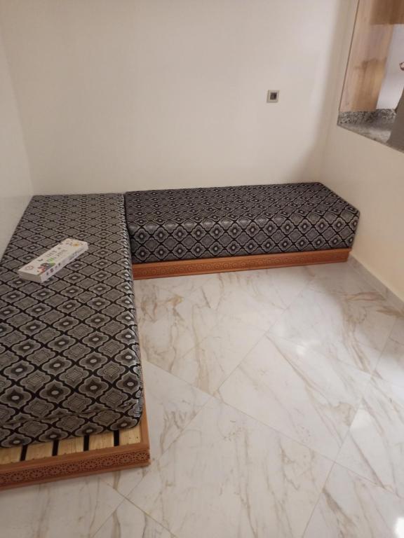 - un lit dans une pièce dotée d'un sol en marbre dans l'établissement Garçonnière, à Azrou