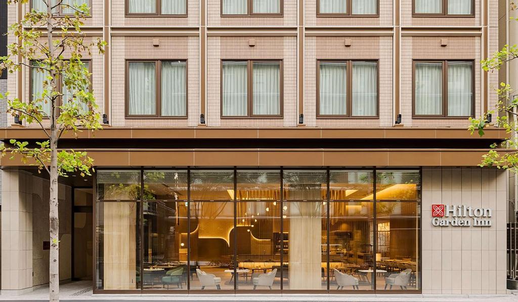 a store front of a building with glass windows at Hilton Garden Inn Kyoto Shijo Karasuma in Kyoto