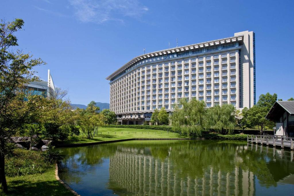 Hilton Odawara Resort & Spa في أوداوارا: مبنى كبير أمامه نهر