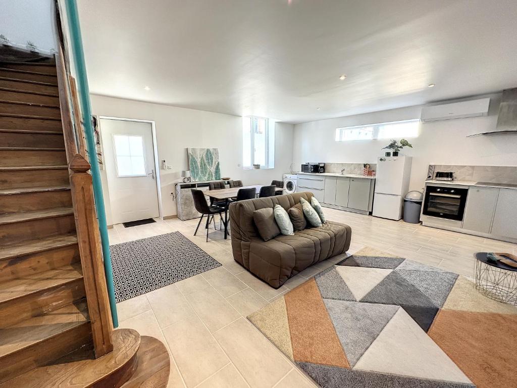 a large living room with a couch and a table at Maison familiale pour 8 pers au centre, vue Pyrénées, salle de jeux et parking in Saint-Gaudens