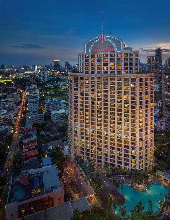 a tall building with a sign on top of it at Conrad Bangkok in Bangkok