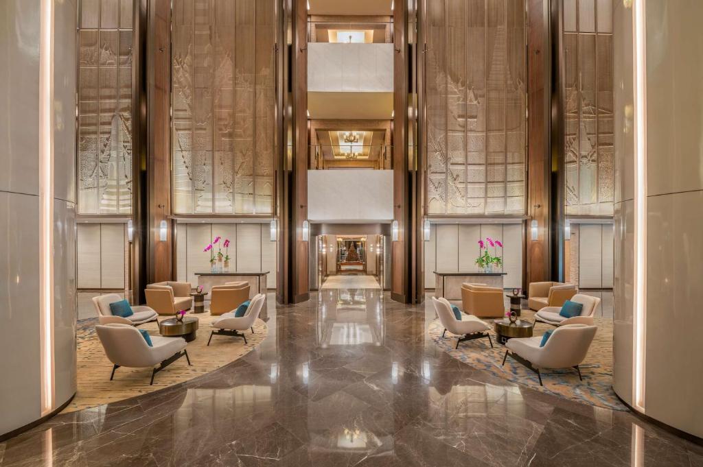 a lobby of a hotel with chairs and tables at Conrad Bangkok in Bangkok