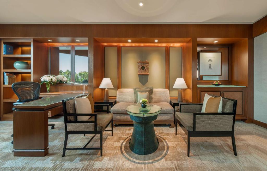a living room with a couch and chairs at Conrad Bangkok in Bangkok