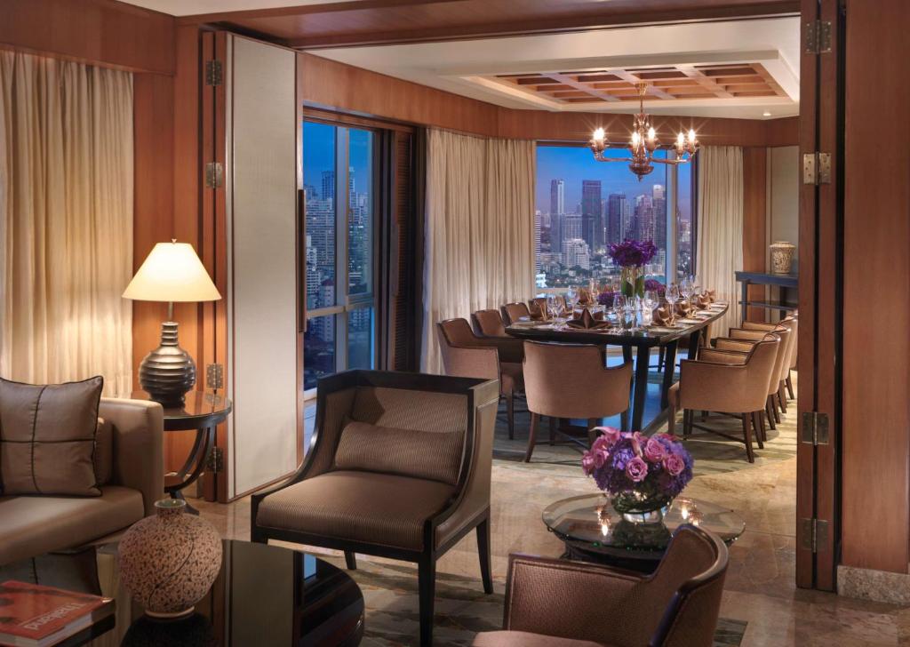 a dining room with a table and a view of the city at Conrad Bangkok in Bangkok