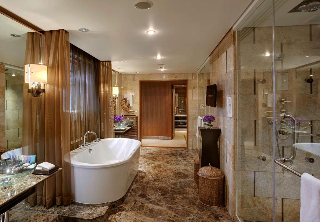 a large bathroom with a tub and a shower at Conrad Bangkok in Bangkok