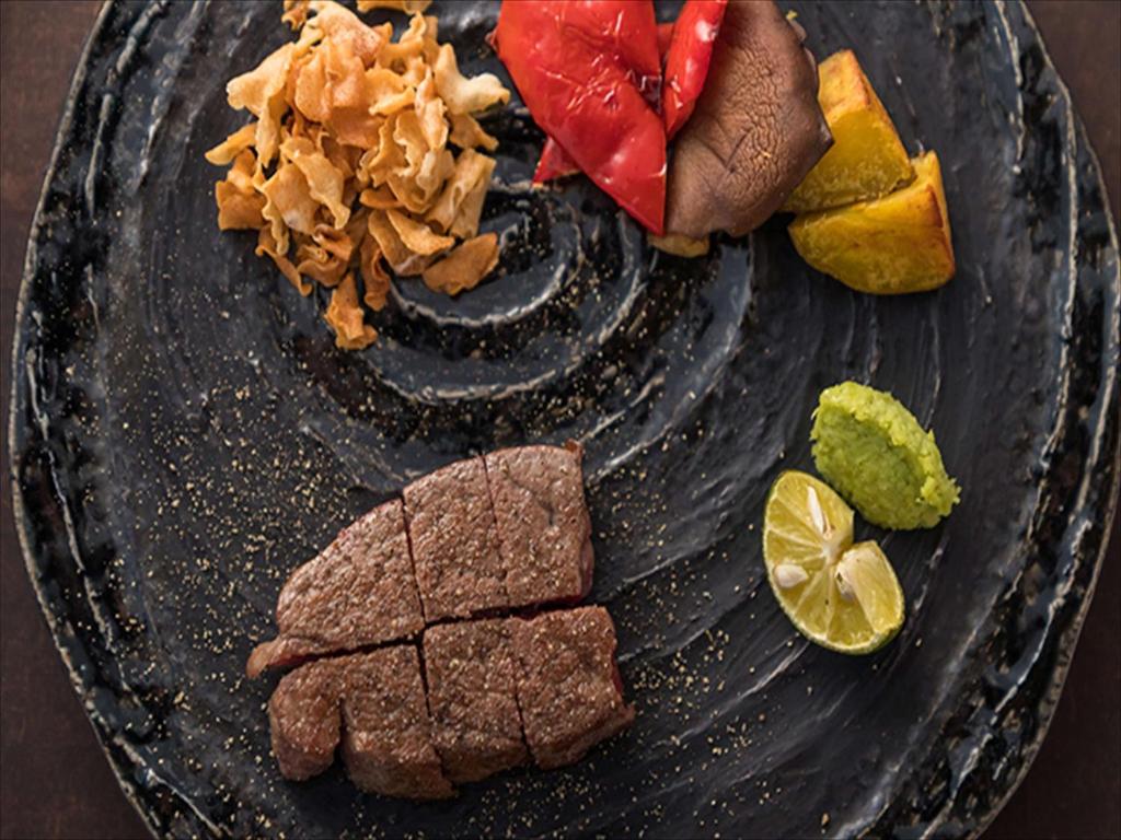 a plate of food with meat and vegetables on it at Conrad Osaka in Osaka