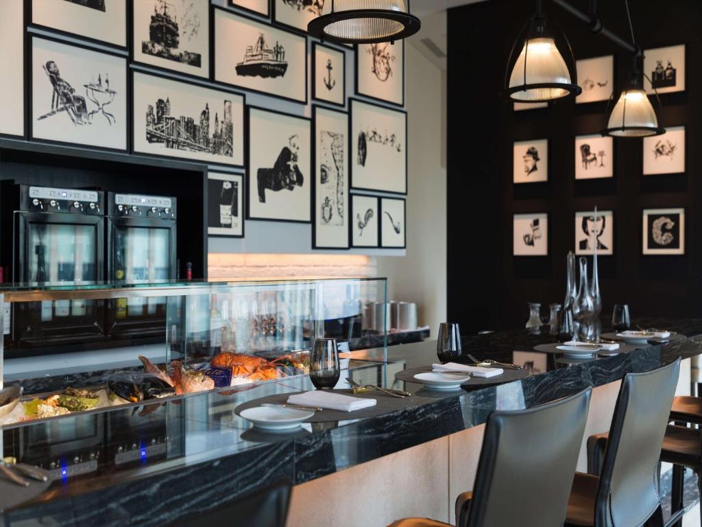 a restaurant with a counter with food on it at Conrad Osaka in Osaka