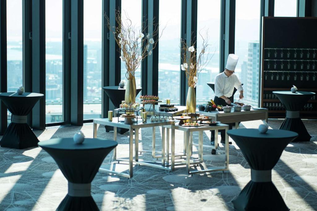 a chef preparing food on a table in a building at Conrad Osaka in Osaka