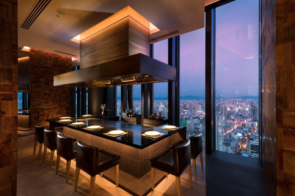 a bar in a restaurant with a view of a city at Conrad Osaka in Osaka