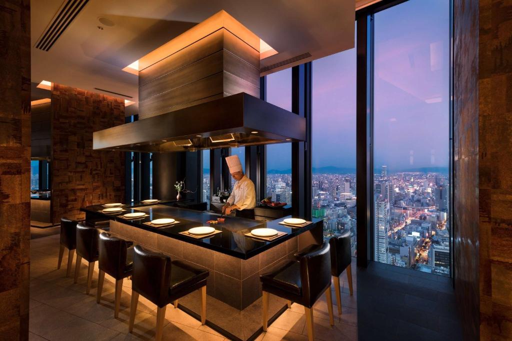 a bar in a restaurant with a view of a city at Conrad Osaka in Osaka