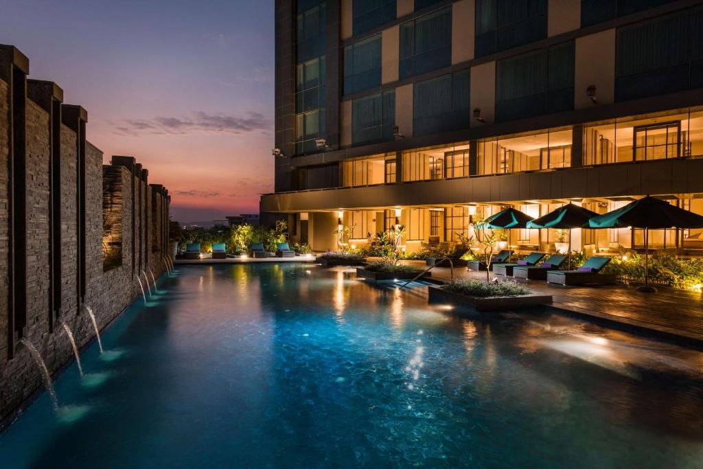 a river in front of a building at night at Conrad Pune in Pune