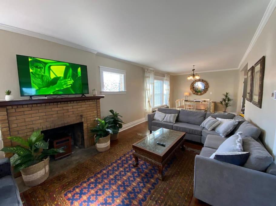 a living room with a couch and a fireplace with a tv at Beautifully remodeled house 1.5 miles from falls. in Niagara Falls
