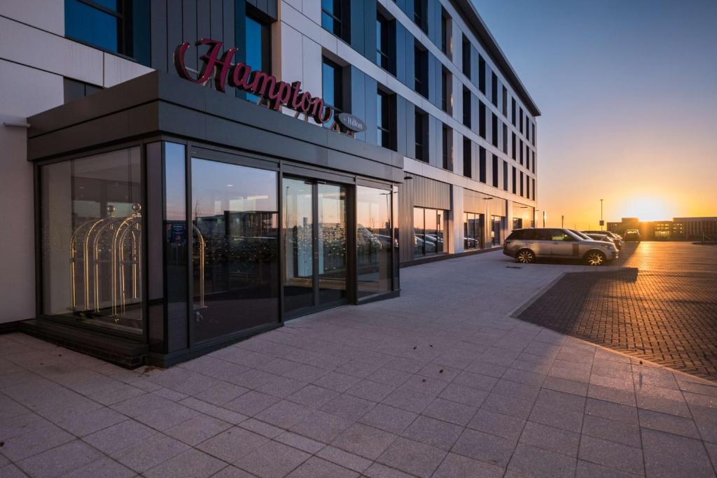 a building with a car parked in front of it at Hampton By Hilton Aberdeen Airport in Dyce