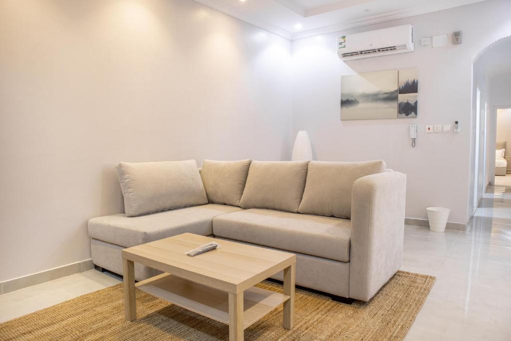 Luxury & Charming Big Apartments in Mudhainib في AR Rummanah: غرفة معيشة مع أريكة وطاولة قهوة