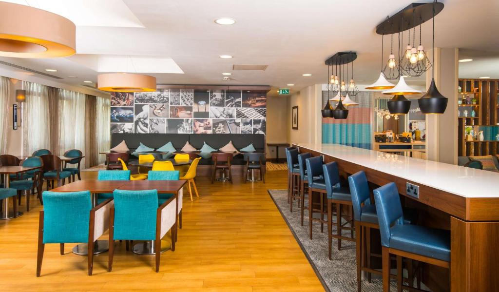 a restaurant with blue chairs and a bar at Hampton by Hilton Birmingham Jewellery Quarter in Birmingham