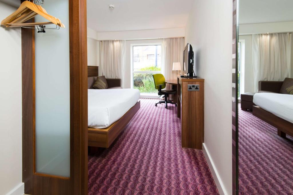a hotel room with two beds and a mirror at Hampton by Hilton Birmingham Jewellery Quarter in Birmingham