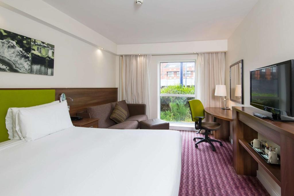 a hotel room with a bed and a desk and a television at Hampton by Hilton Birmingham Jewellery Quarter in Birmingham