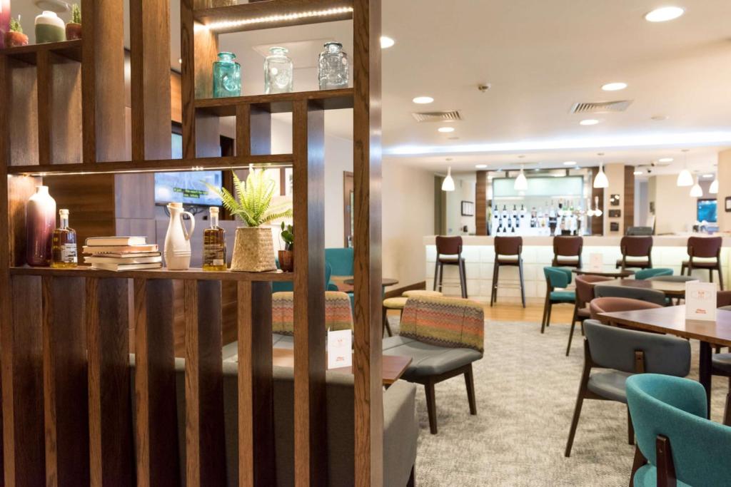 a restaurant with tables and chairs and a bar at Hampton by Hilton Birmingham Jewellery Quarter in Birmingham
