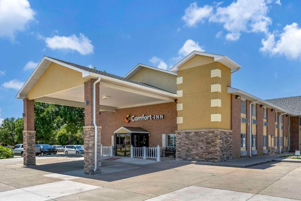 a front view of a building with a car dealership at Comfort Inn Hastings in Hastings