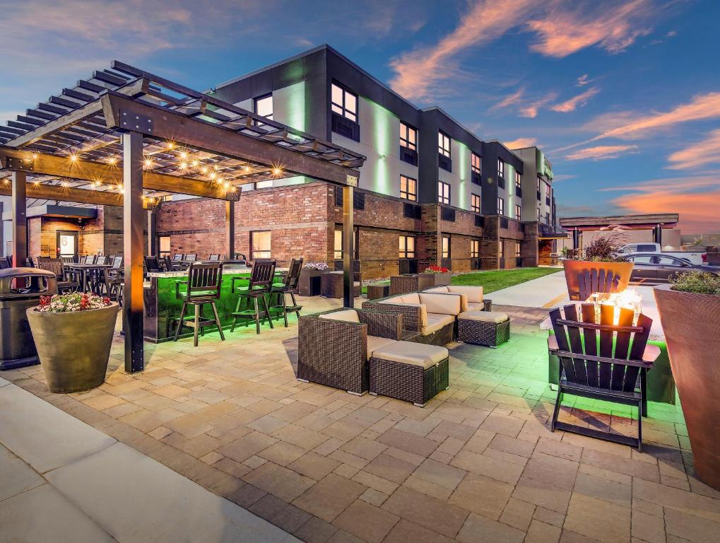 a patio with chairs and tables in front of a building at Holiday Inn & Suites St. Cloud, an IHG Hotel in Saint Cloud