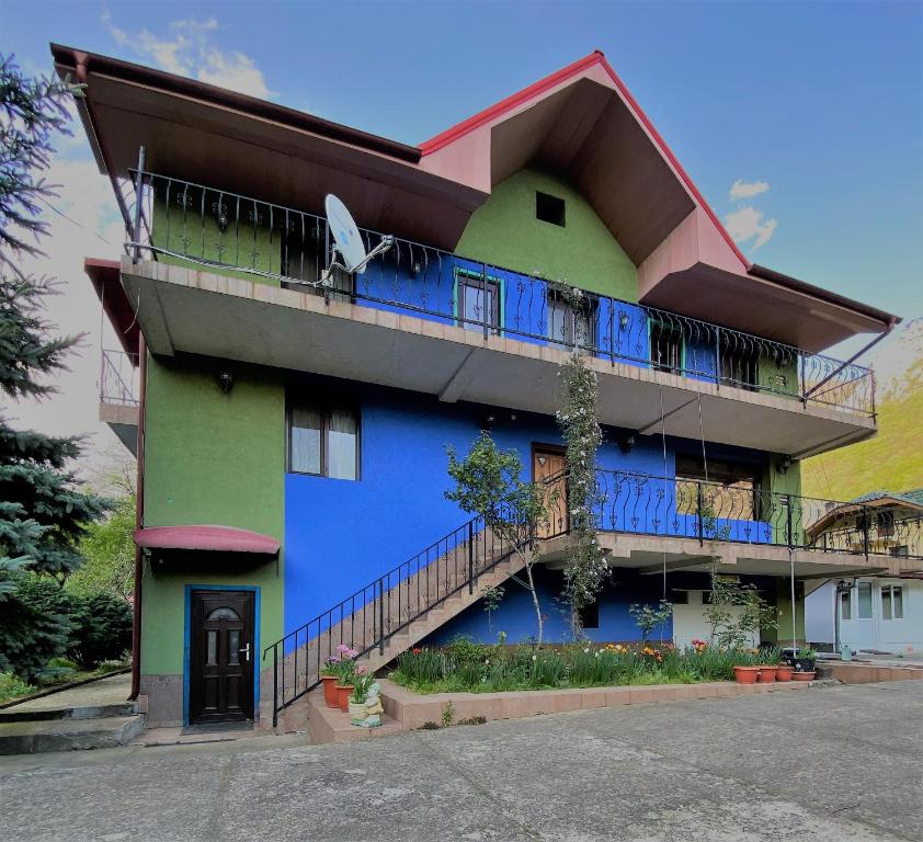 - un bâtiment bleu et vert avec un balcon dans l'établissement Casa Aura, à Băile Herculane