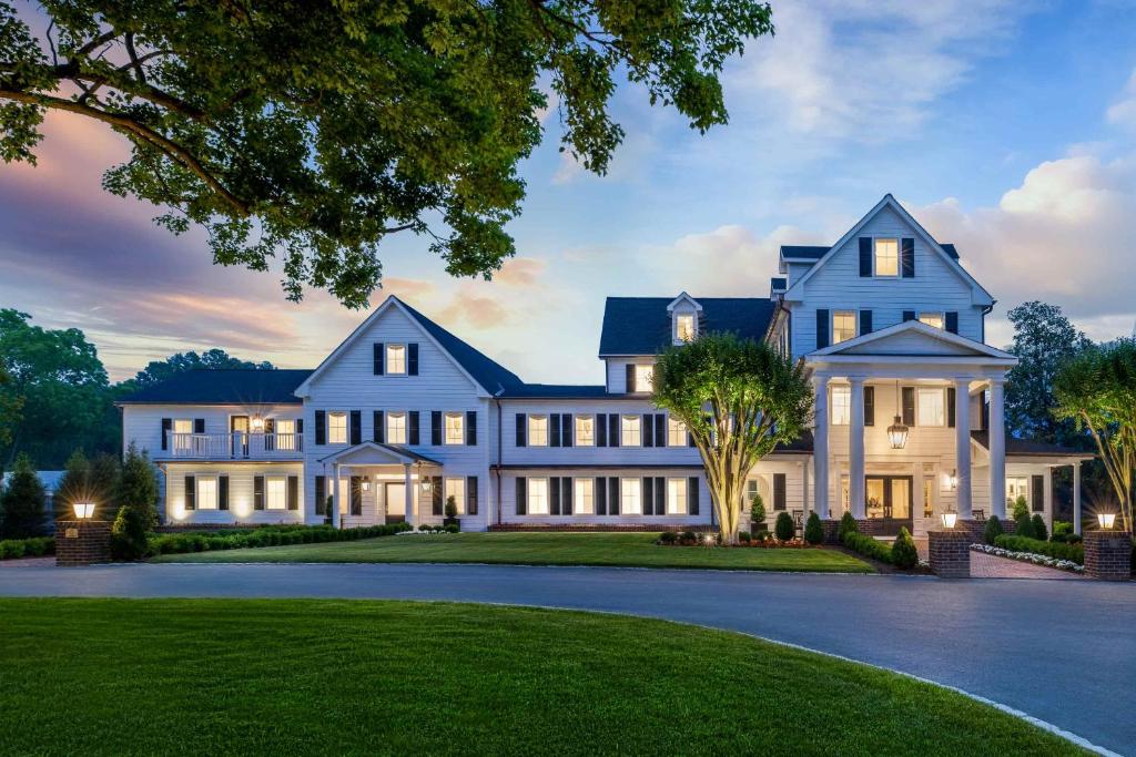 a large blue house with a lawn at The Oaks Waterfront in Saint Michaels