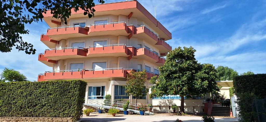 un edificio con balconi rossi sul lato di Hotel Le Pleiadi a San Felice Circeo
