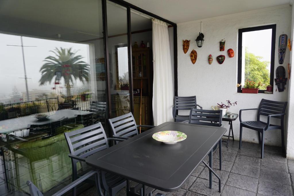 a dining room with a table and chairs and a balcony at Departamento La Palmera in Viña del Mar