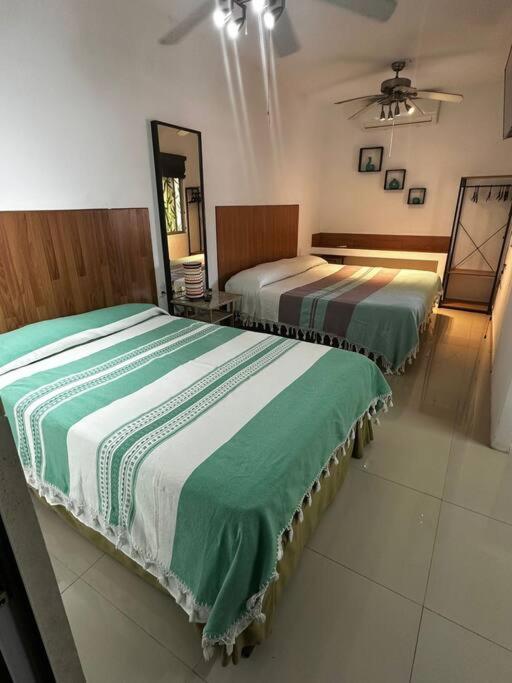 a room with two beds in a room with a fan at Departamento 5 Los Corales (tipo estudio) in Mezcales