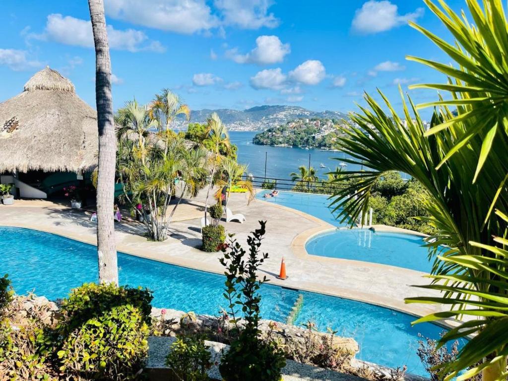 un complejo con piscina y vistas al agua en CasaBlancaGrand Colibrí en Acapulco