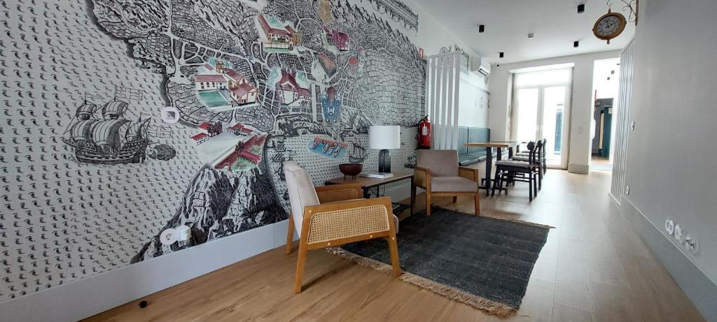 a living room with a wall with a mural at Angra Heritage - City Center Hostel in Angra do Heroísmo