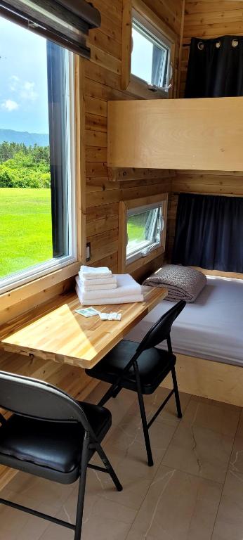 a tiny house with a desk and a bed at Motel du Haut Phare in Cap-des-Rosiers
