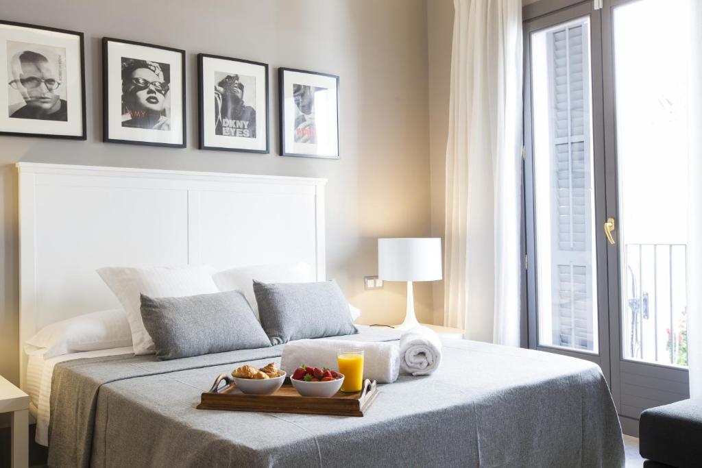 a bedroom with a bed with a tray of fruit on it at Kare No Apartments by Sitges Group in Sitges