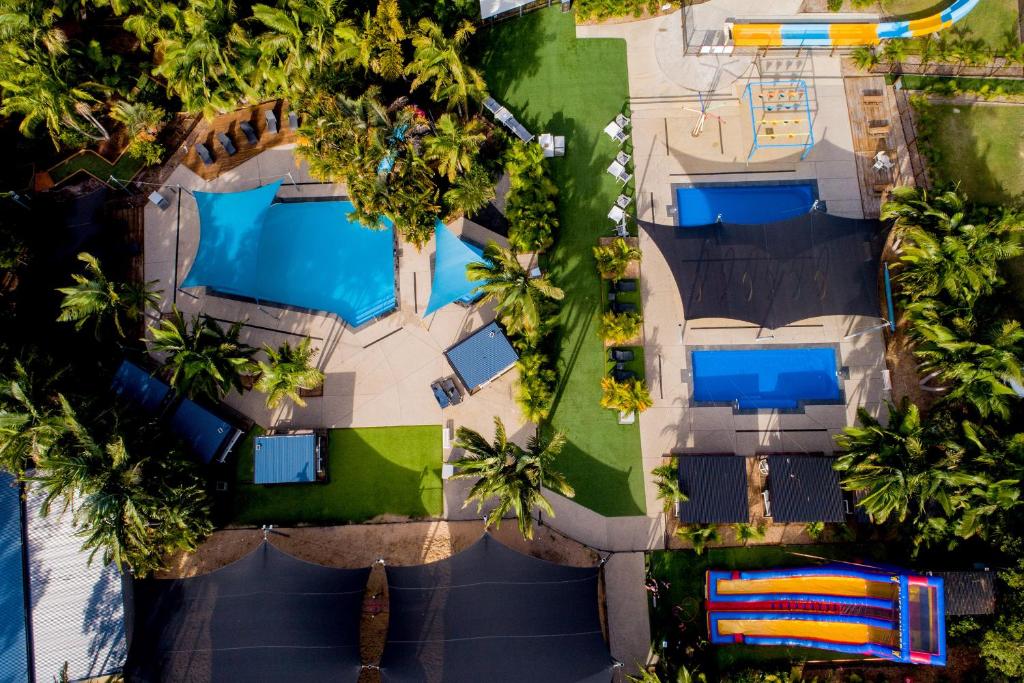 an overhead view of a pool in a resort with palm trees at Solitary Islands Resort in Wooli