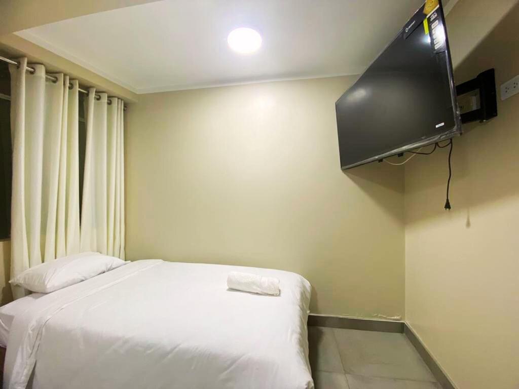 a bedroom with a bed and a flat screen tv at ROYALS RESORT in Huaraz