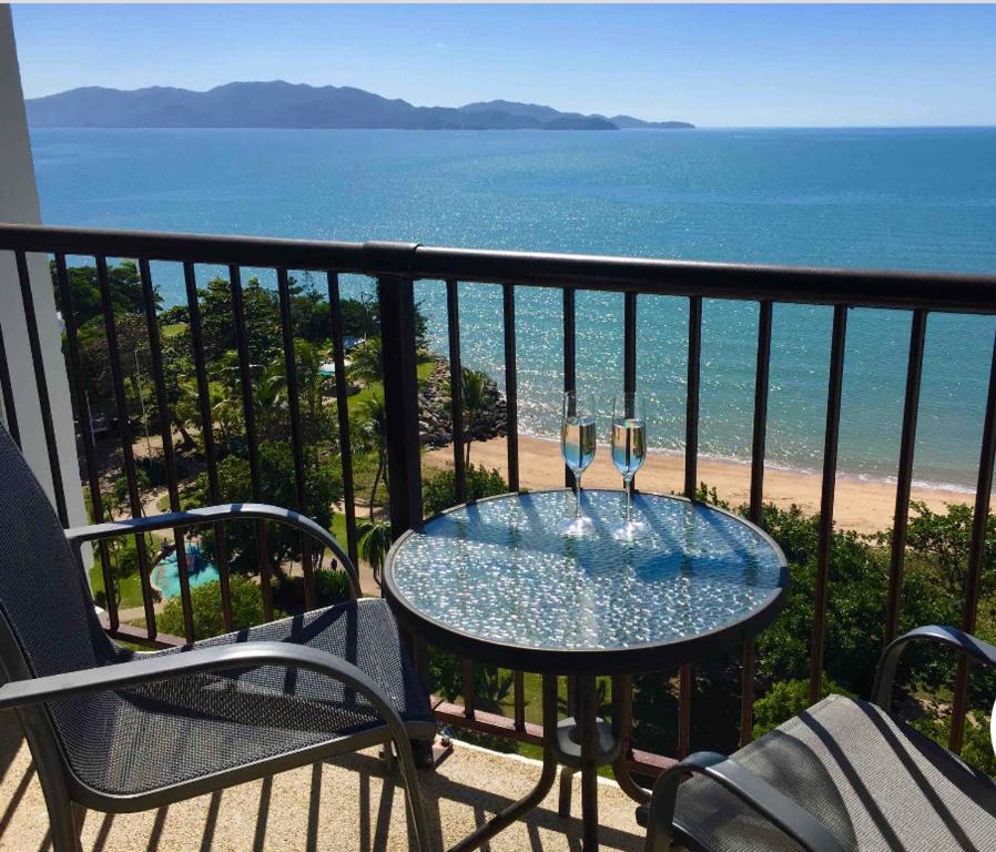 einen Tisch mit zwei Weingläsern auf einem Balkon mit Meerblick in der Unterkunft Beachfront Balcony in North Ward