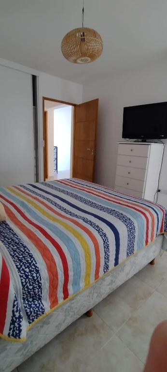 ein Schlafzimmer mit einem Bett mit einer bunten Decke in der Unterkunft Duplex cómodo y elegante zona alta de Mendoza in El Challao
