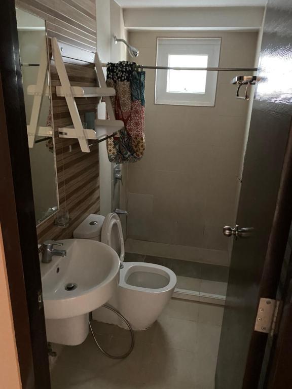 a bathroom with a toilet and a sink at Abreeza chills place 1815 in Davao City