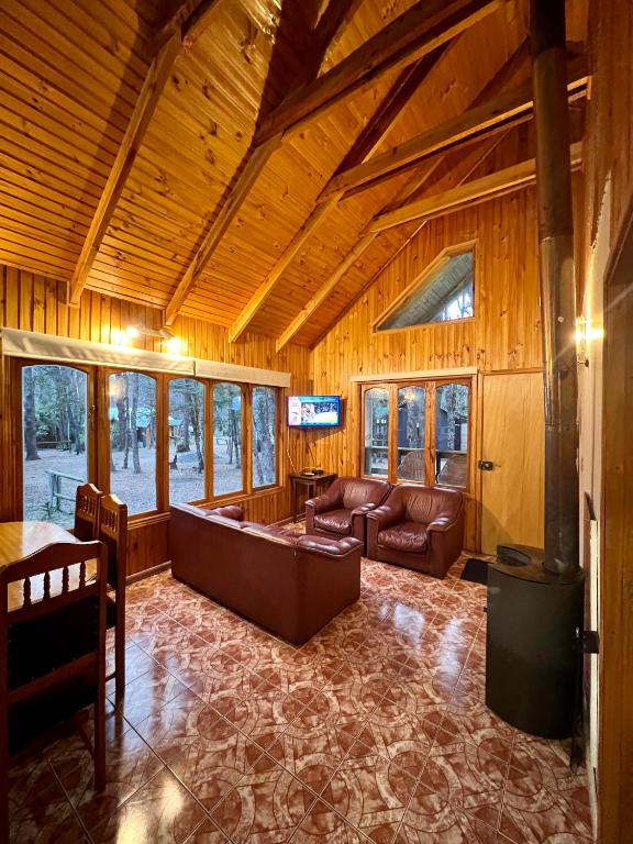 una sala de estar con un sofá y una mesa en Cabañas Bosque las Trancas, en Las Trancas