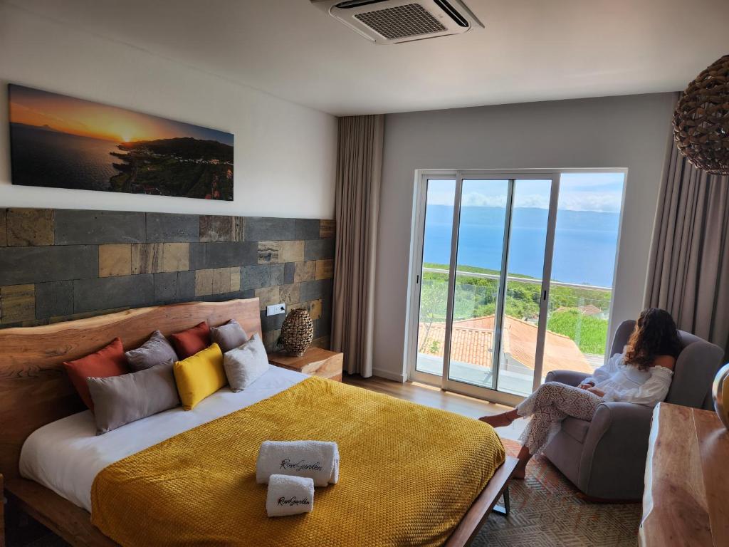 a woman sitting in a chair in a bedroom with a bed at Rosegarden View in Velas