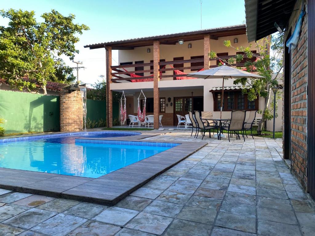 a house with a swimming pool and a patio at Maravilhosa casa Ponta de Serrambi in Porto De Galinhas