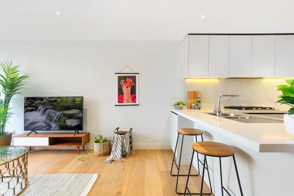 a kitchen with a counter and stools in a room at Urban Retreat in Surry Hills l 2 Bedroom Property with Parking in Sydney